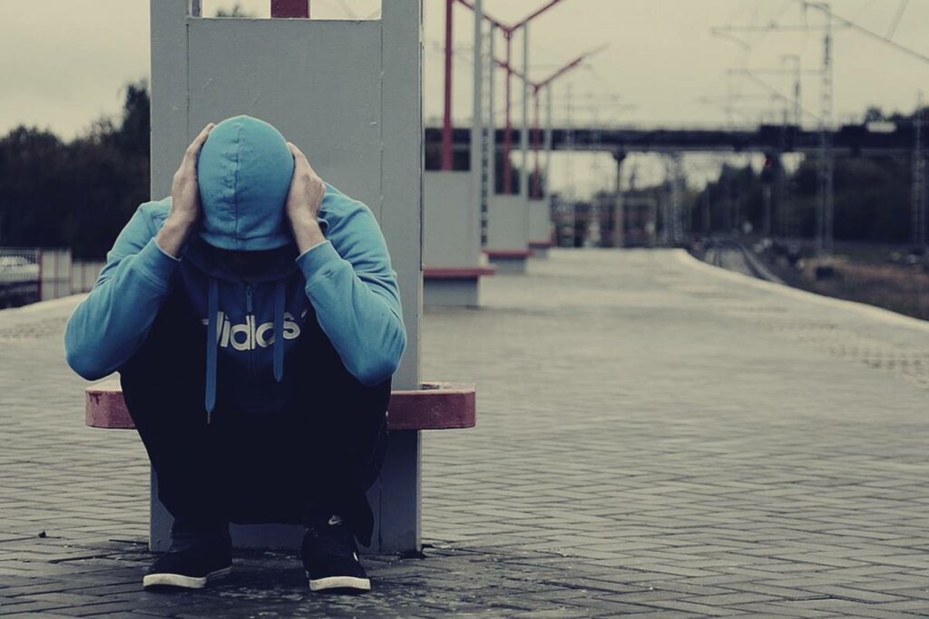 Chico en una estación de tren pensando en el miedo a volverse loco