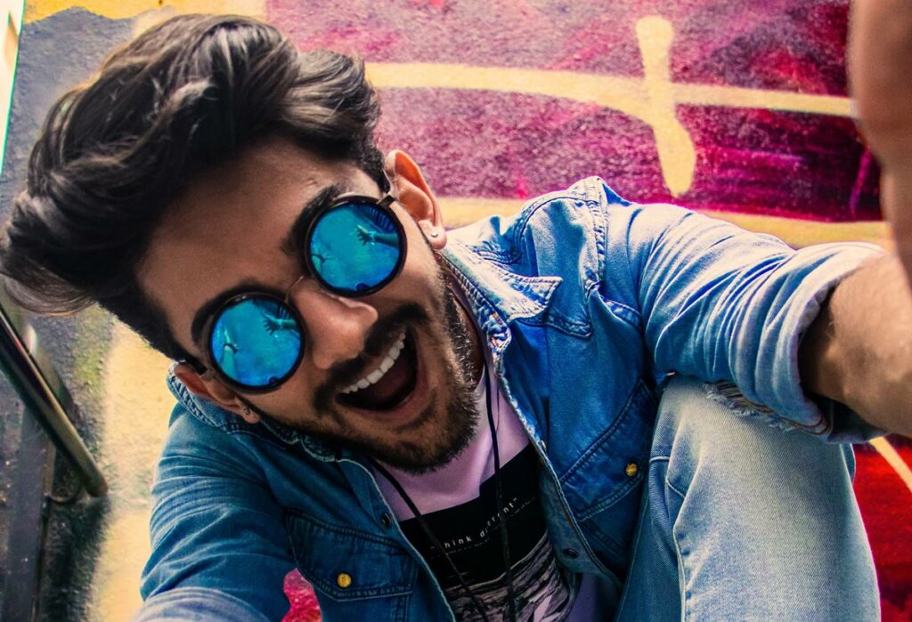 Chico eufórico con gafas azules en fase de hipomanía