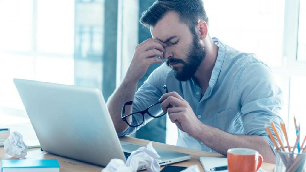 Hombre agotado por los conflictos en el teletrabajo