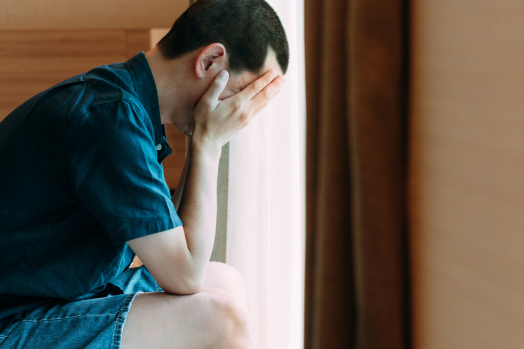 Hombre en la cama preocupado pensando en cómo empezar el día cuando tengo depresión