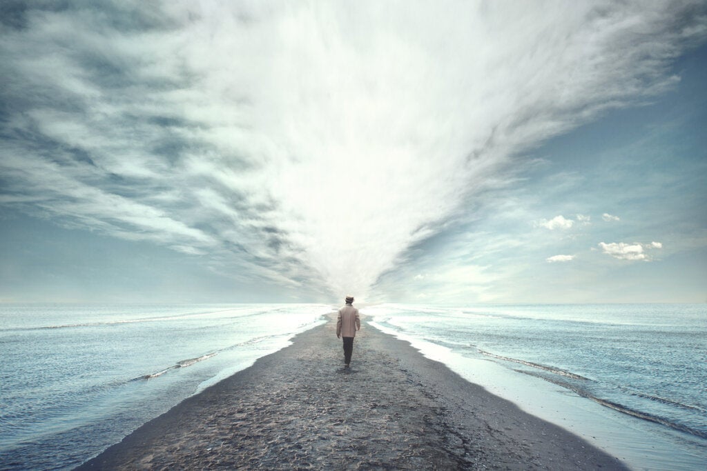 Homem caminhando em direção ao mar pensando em como ter compaixão por si mesmo