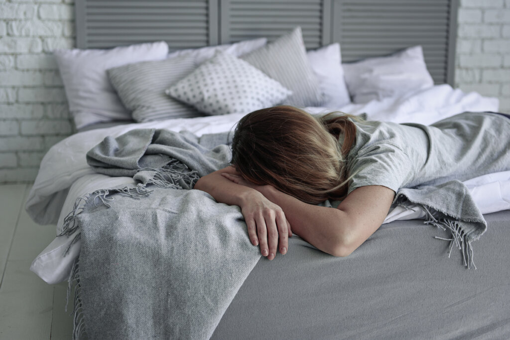 Femme au lit avec clinomanie