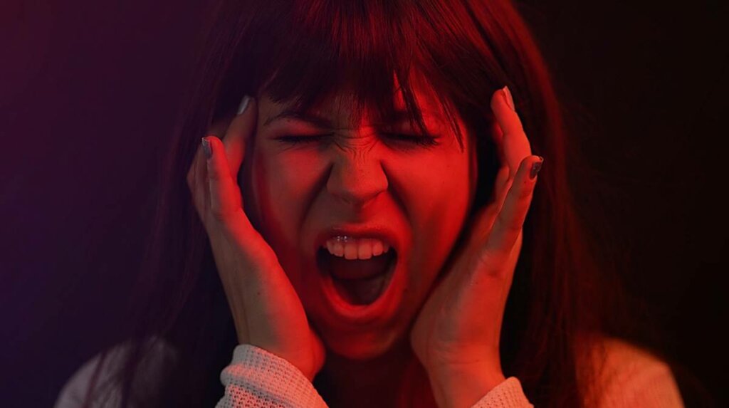 Chica gritando como efecto de las emociones expansivas