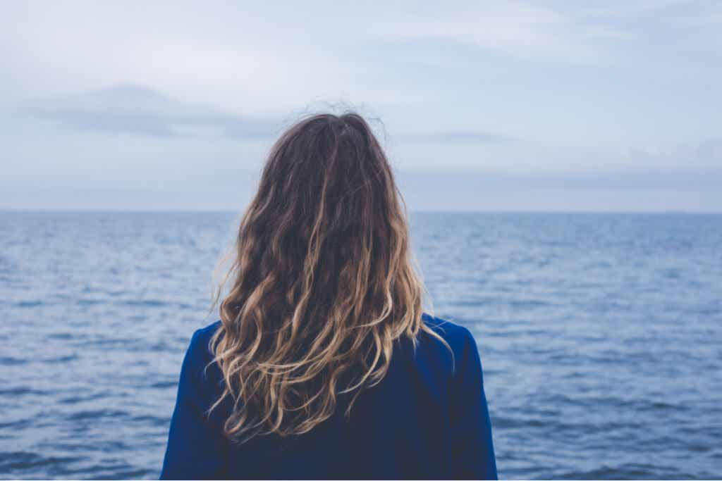 Mujer mirando al mar con miedo a lo desconocido