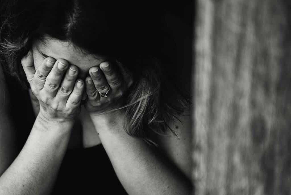 Mujer tapándose la cara para representar la relación entre vergüenza y depresión