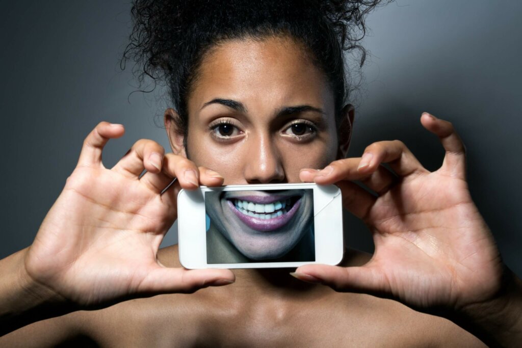 mujer con móvil experimentando experimentando las emociones que se comparten en redes sociales