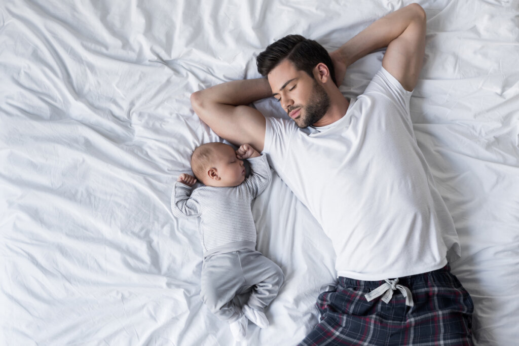 Padre durmiendo con un bebé