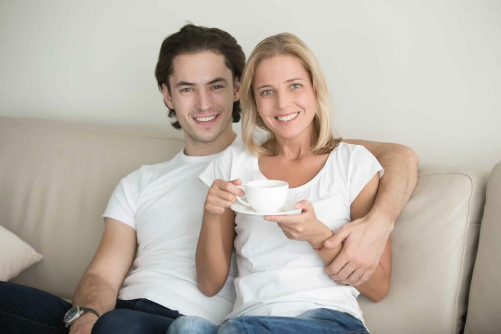 Pareja sentada en el sofá representando que mi familia no acepta que mi pareja sea mayor que yo