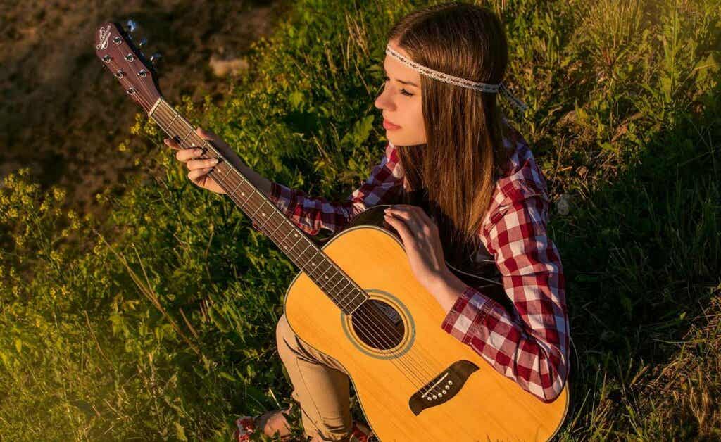 Chica tocando guitarra sintiendo las emociones musicales