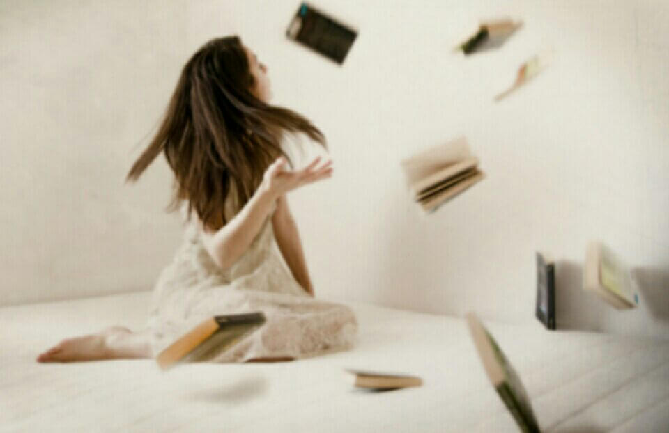 Chica con libros volando debido a la telequinesis