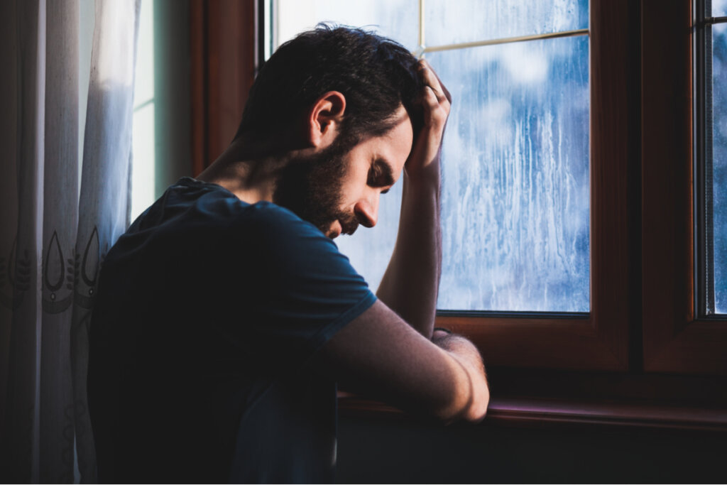 Man feeling guilt by the window