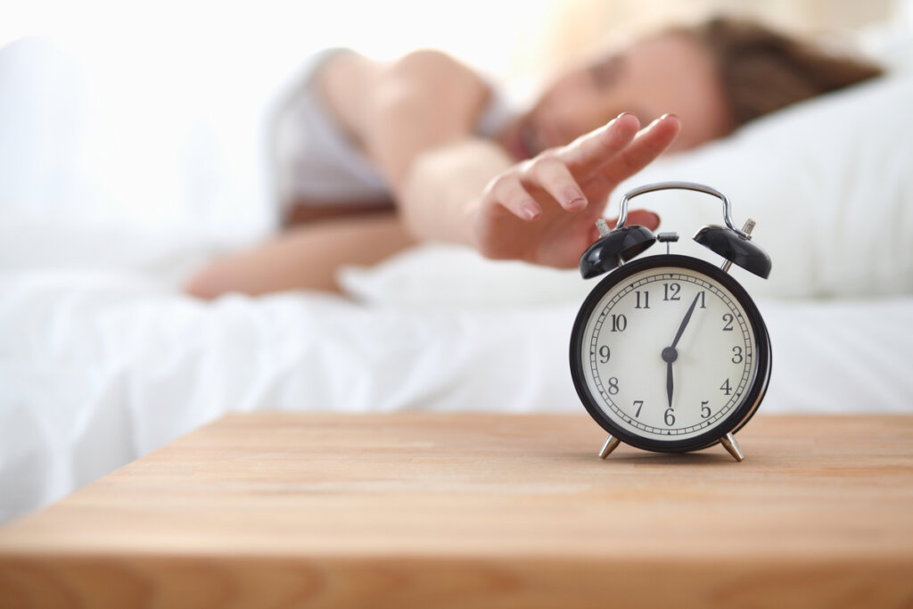 Woman turning off the alarm clock