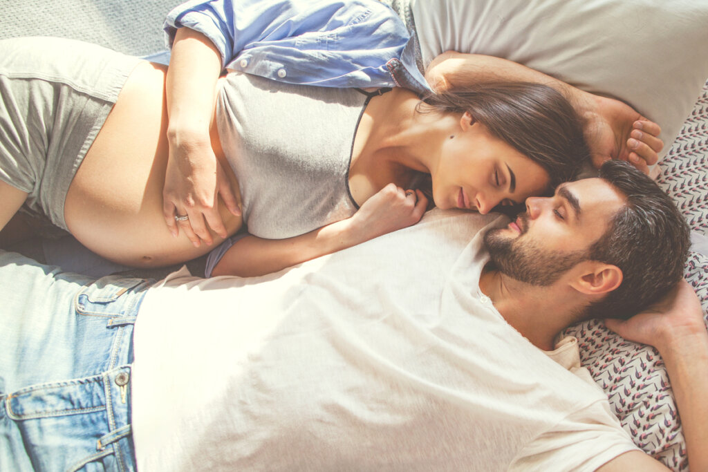 Mujer embarazada en la cama con su marido