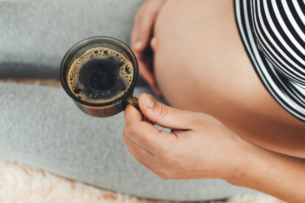 Pregnant woman having breakfast coffee