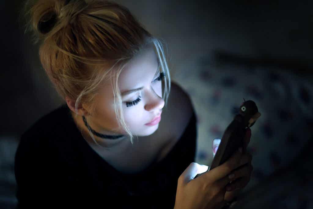 Mujer mirando el teléfono móvil creando su autobiografía digital