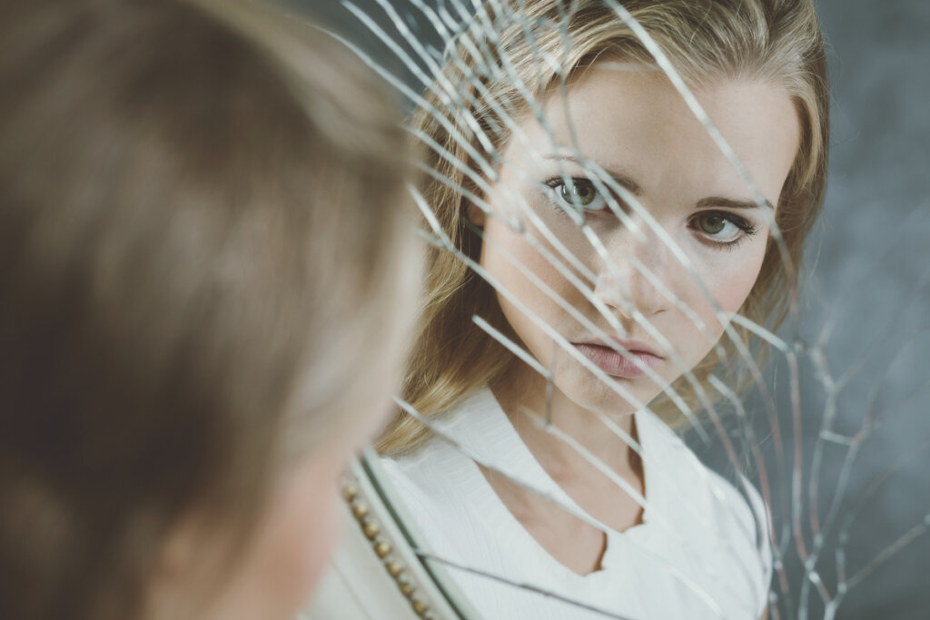 Kobieta patrząca w zbite lustro