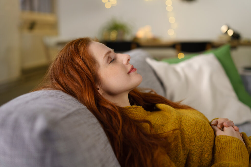 Woman with eyes closed smiling, representing flow and engagement