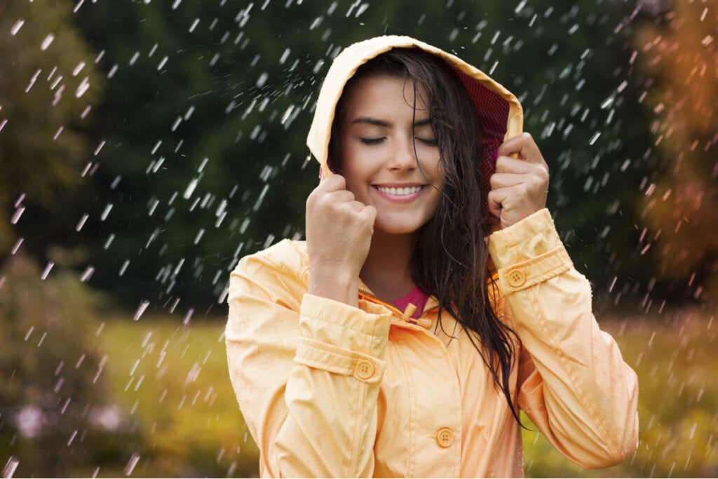 Mujer sonriendo mientras llueve