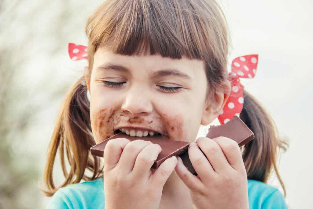 Niña comiendo chocolate simbolizando la importancia de Busca lo que te emocione