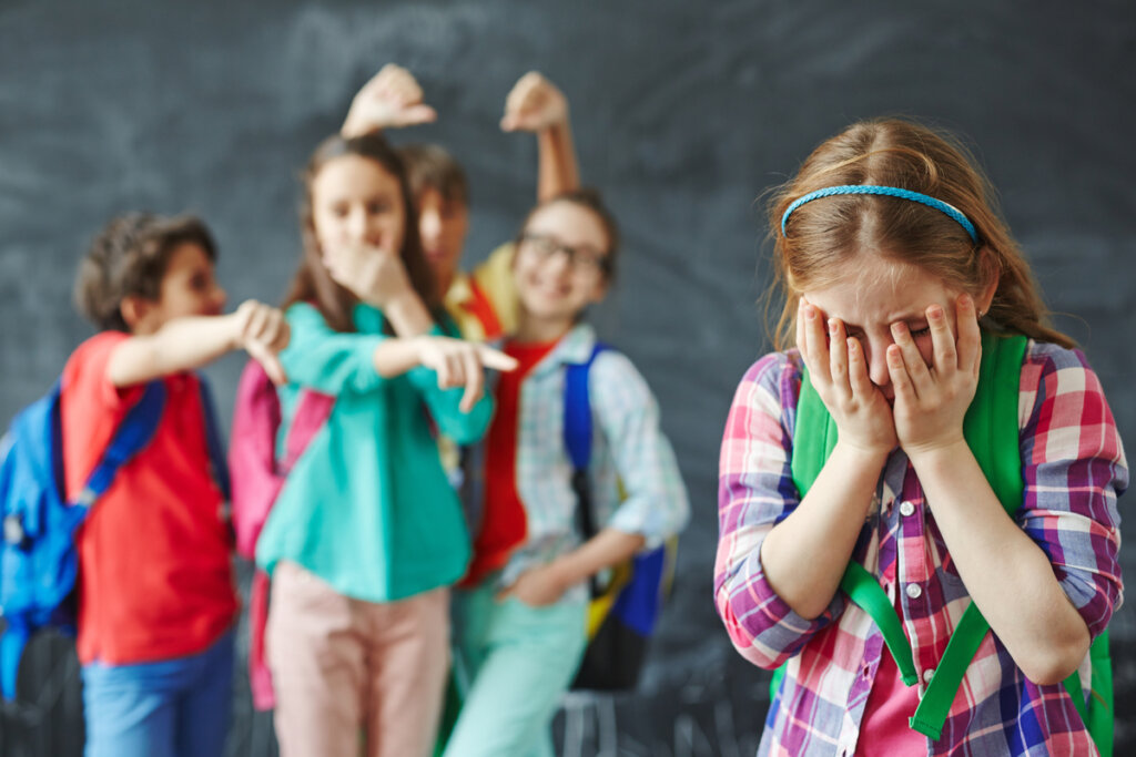 Niños riéndose de su compañera de clase
