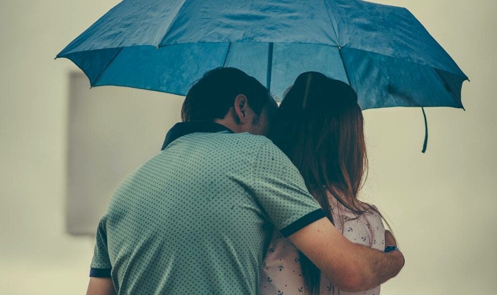 Pareja bajo el paraguas representando la diferencia entre amor infantil y amor maduro