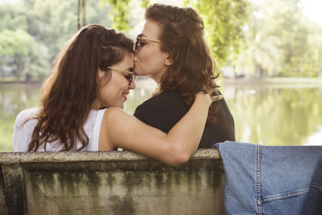 Chica besando en la frente a su pareja