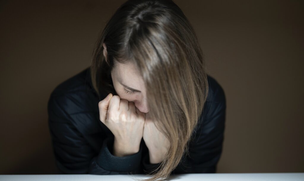 Chica con la cabeza baja pensando en que tengo miedo a sentirme siempre ansioso y deprimido