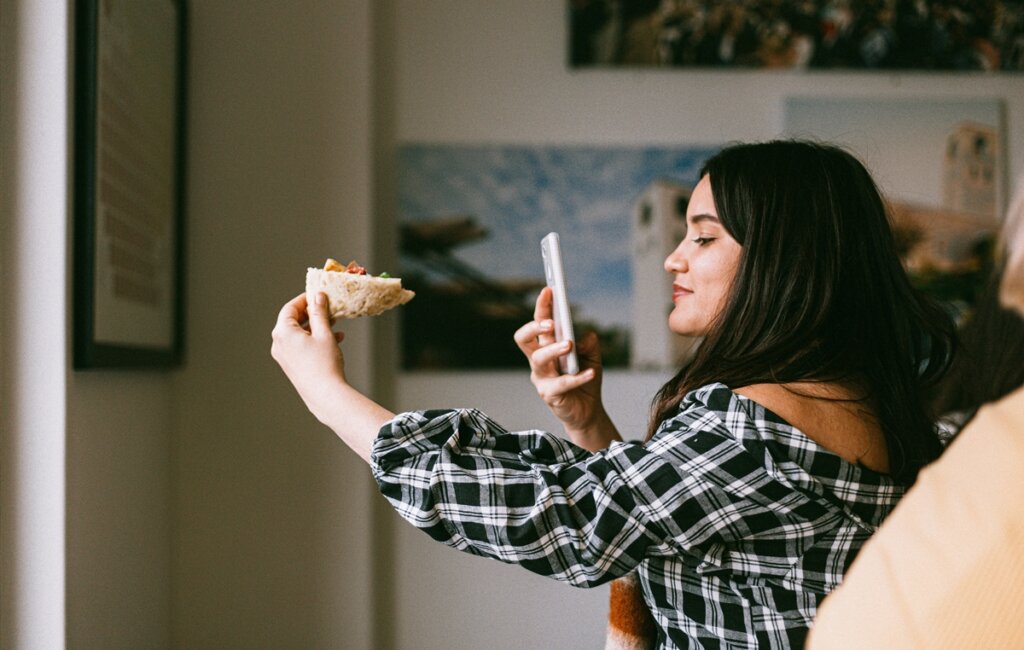 Fille prenant des photos de sa nourriture représentant des influenceurs alimentaires