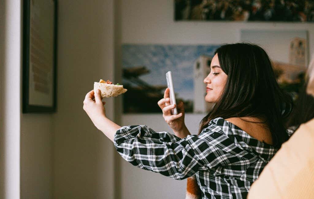 Chica haciendo fotos de su comida representando a los influencers en comida