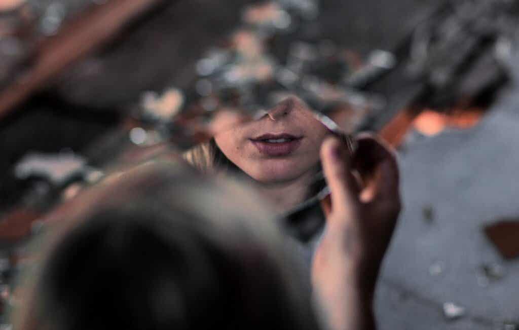 mujer ante espejo roto representando a las Hijas que no recibieron amor