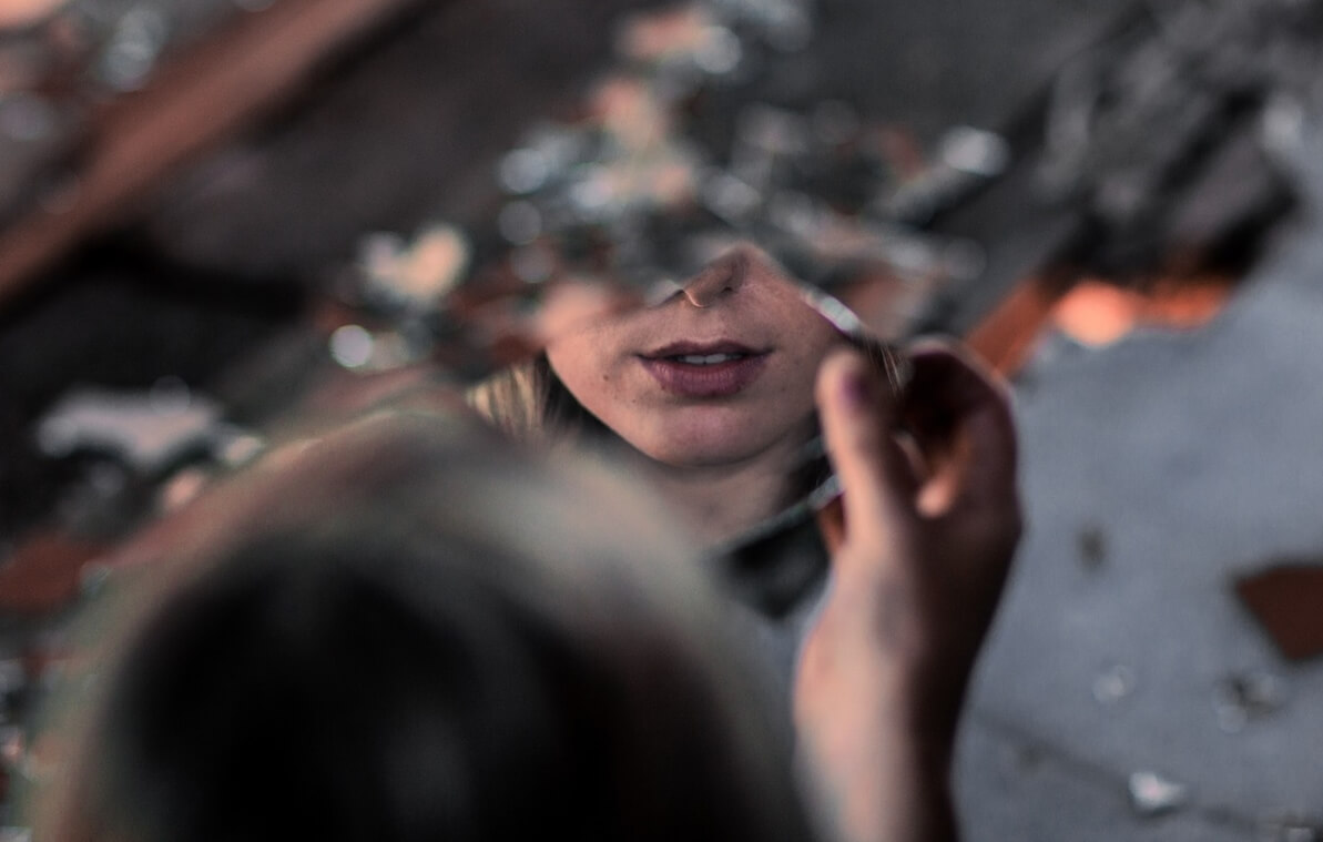 Mujer ante cristal que sufre el síndrome de Orfeo