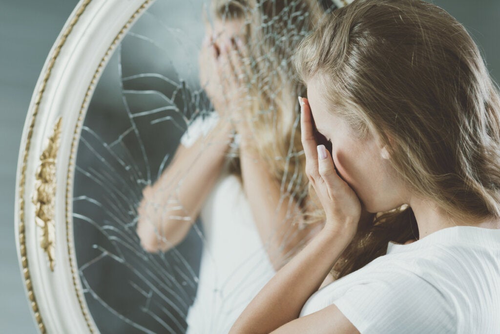 Vrouw voor gebroken spiegel