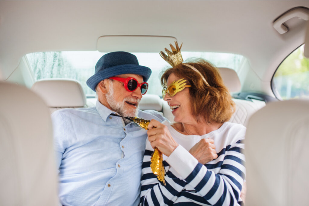 Modent par med sjove briller sidder på bagsæde i bil