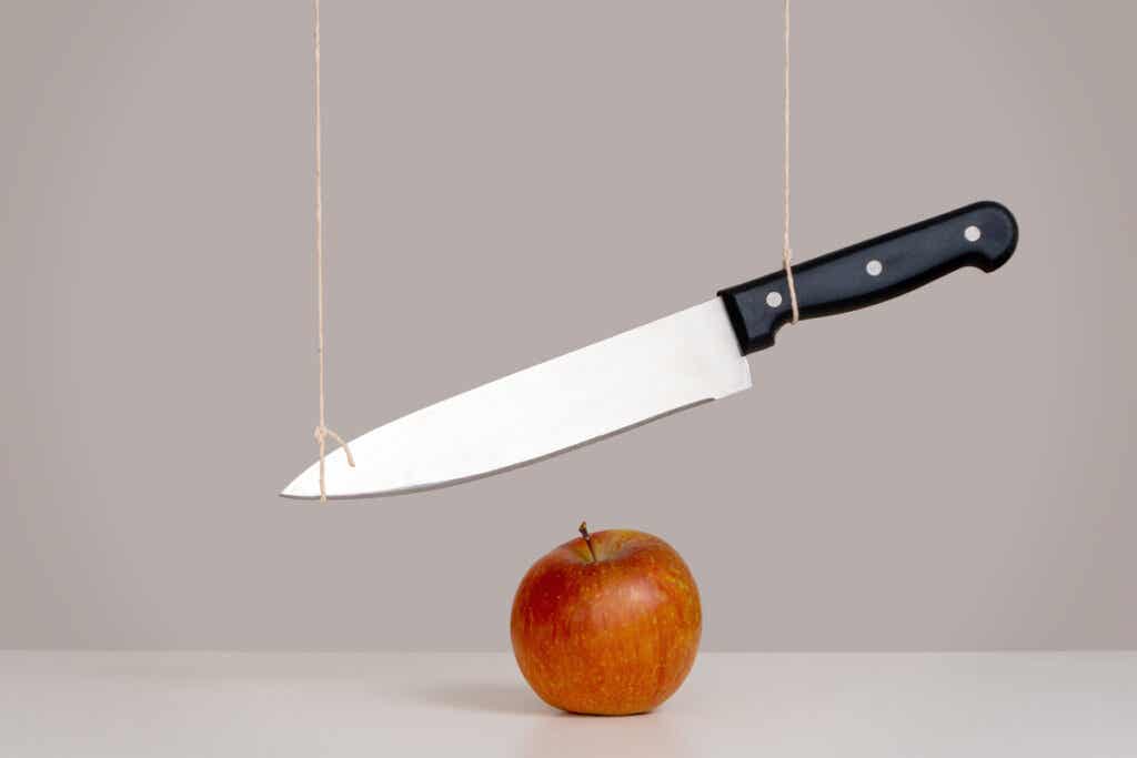 Cuchillo sobre manzana para representar el concepto de la espada de Damocles