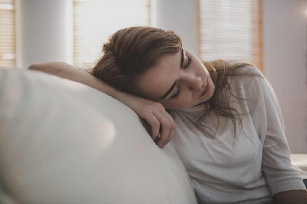 Mujer cansada en el sofá necesitando un descanso emocional