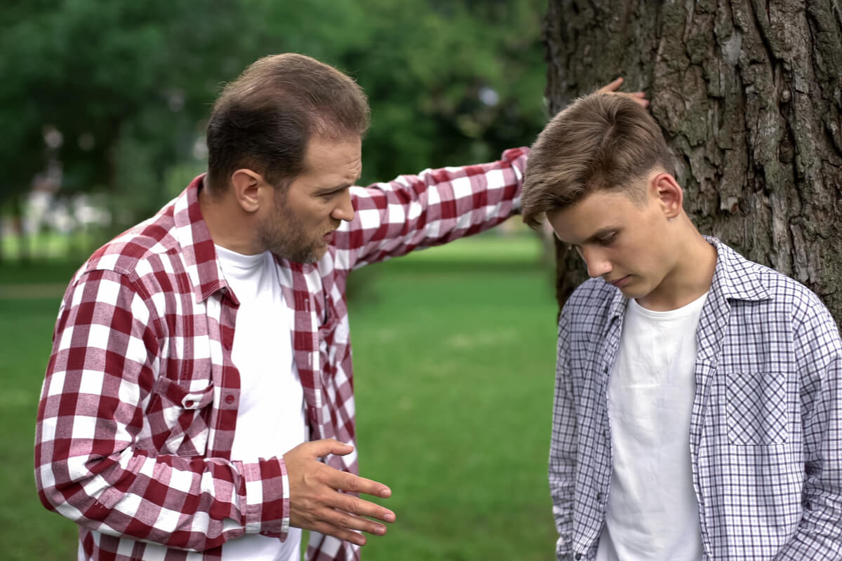 Padre hablando con su hijo adolescente