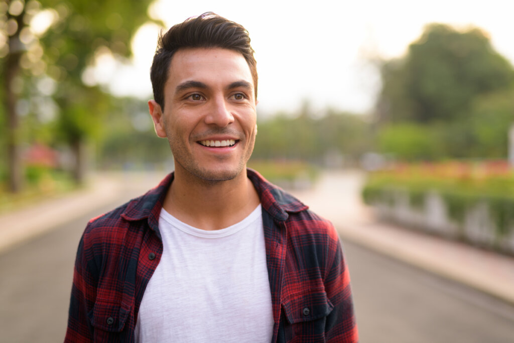 Chico joven sonriendo pensando cómo pensando cómo respetarte a ti mismo