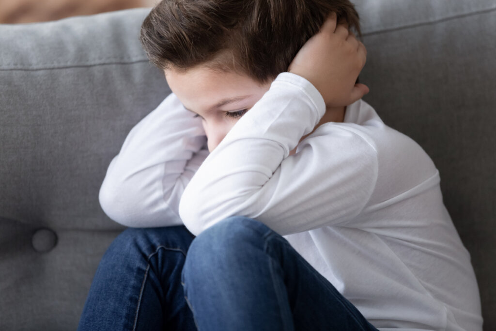 Niño enfadado con las manos en la cabeza