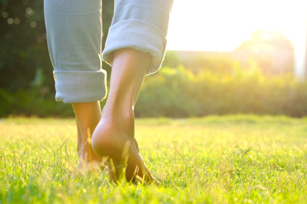 Person walking barefoot on grass