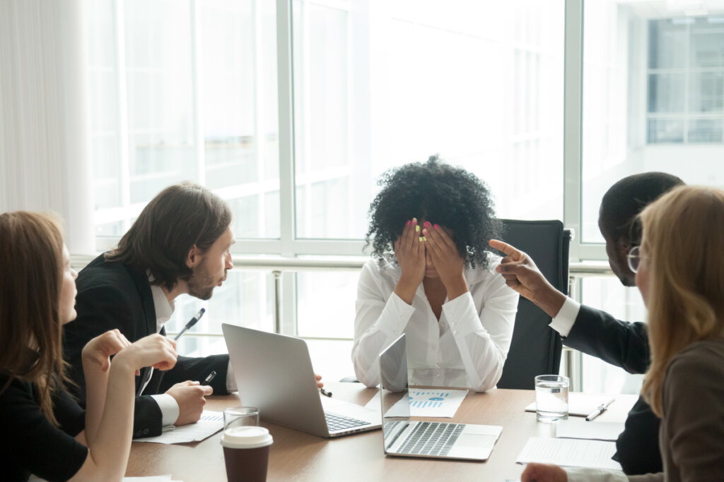 Personas discriminando a una compañera de trabajo por prejuicios