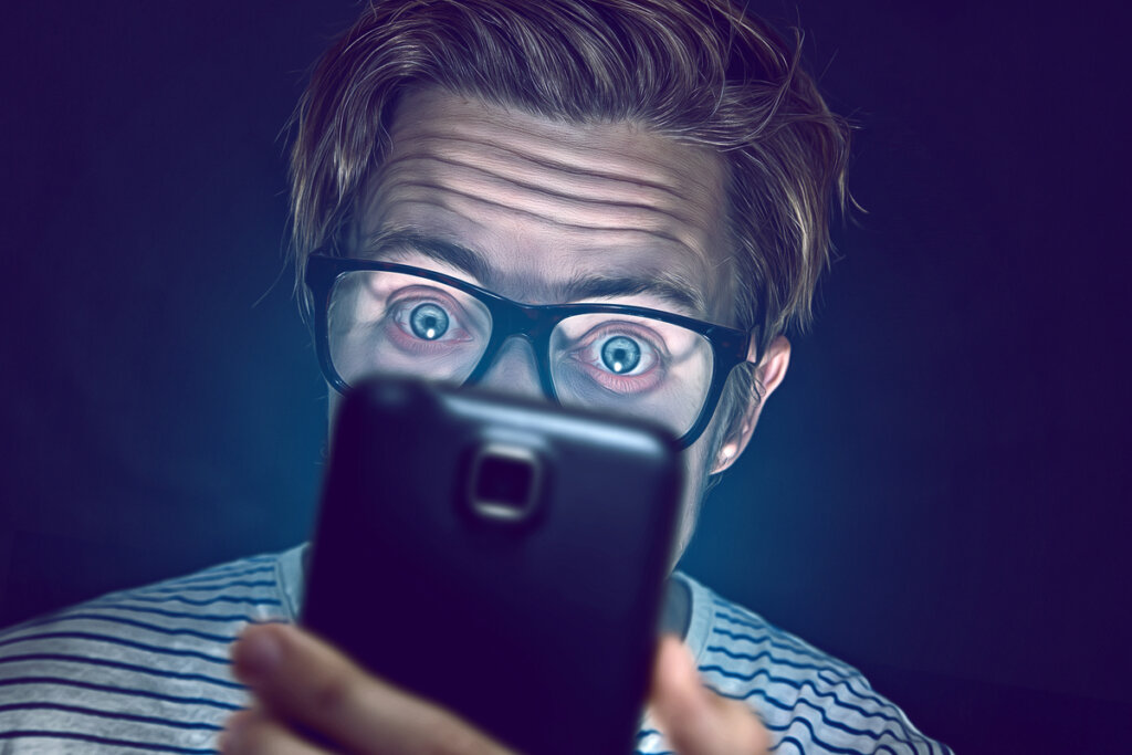 Uitgeputte man die naar mobiel kijkt