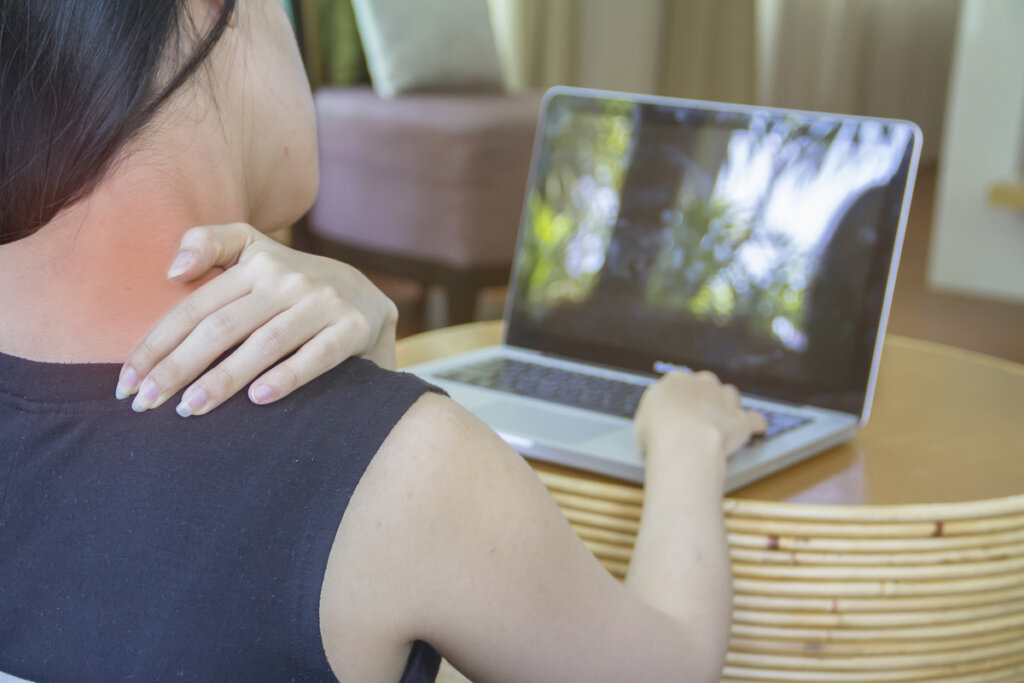 Mujer con dolor en el cuello por la postura con el ordenador