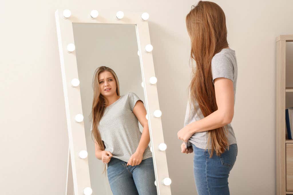 Meisje kijkt met afschuw naar haar spiegelbeeld