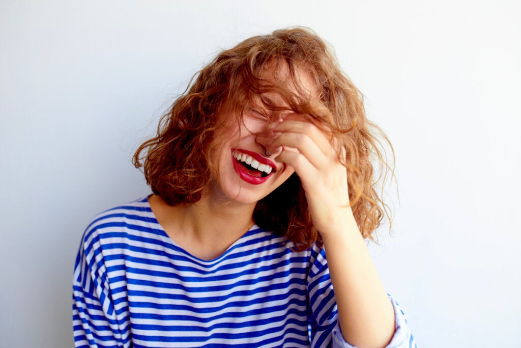 Mujer riendo debido a las preguntas divertidas para sorprender a alguien