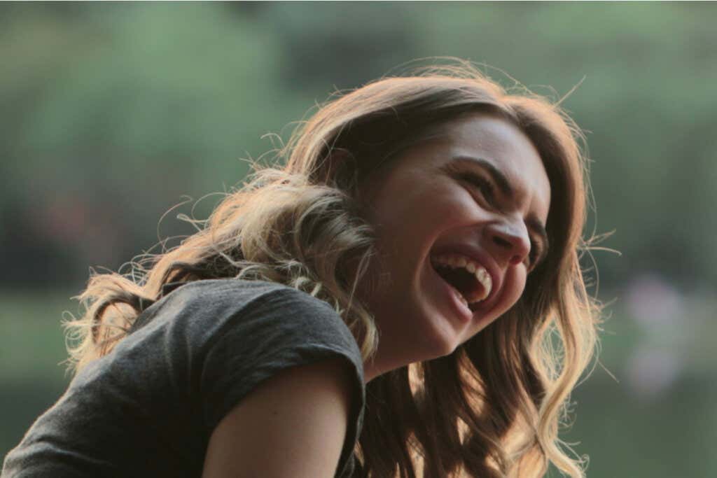 Woman laughing, showing it's important to develop a sense of humor.