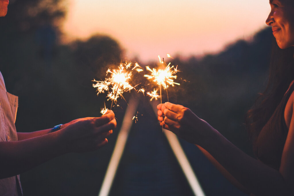 Pareja con bengalas pensando en el amor confluente