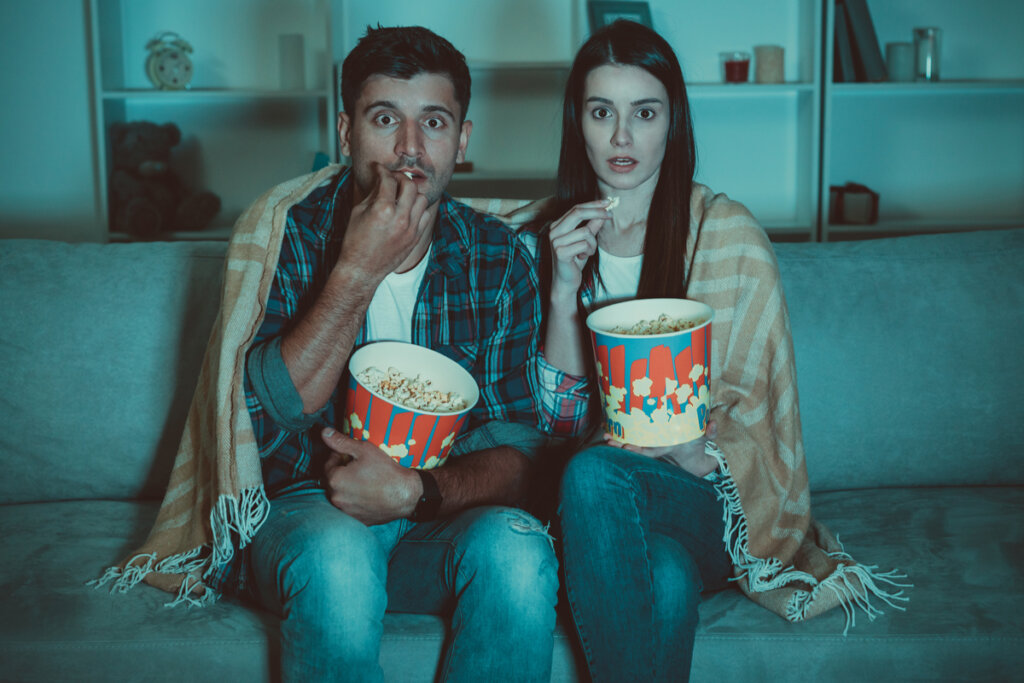 Pareja sorprendidos disfrutando de las historias con finales felices