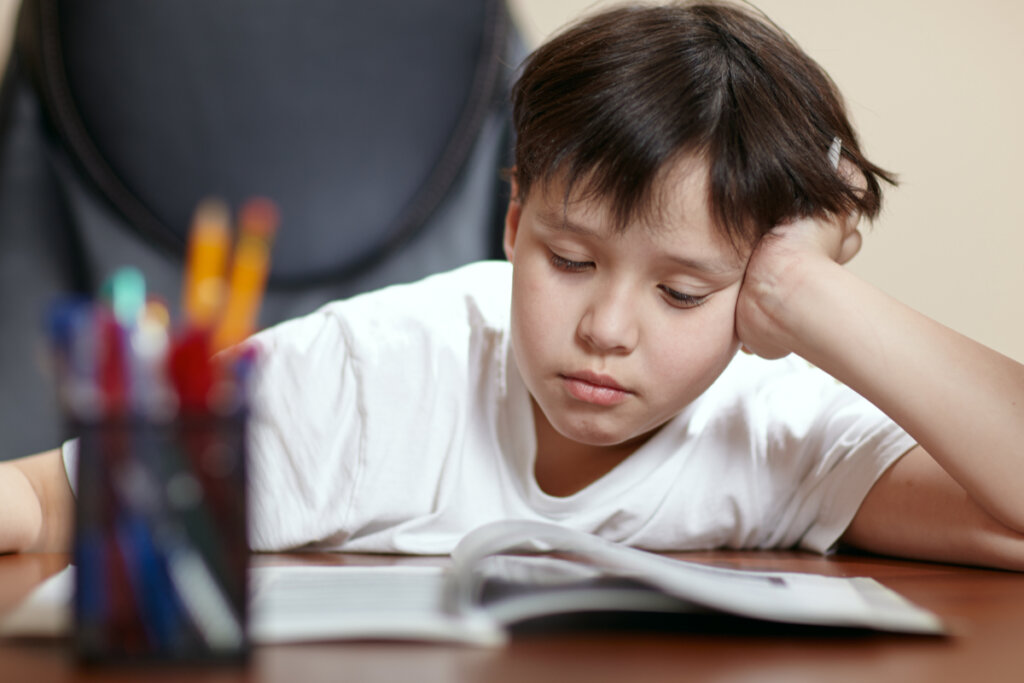 Niño estudiando agobiado simbolizando la importancia del desayuno en el rendimiento escolar