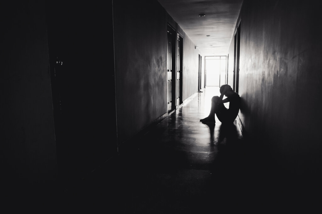 Niño sentado en el suelo en la oscuridad