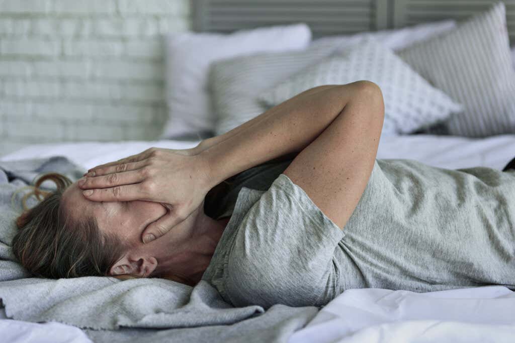 Mujer con ansiedad en la cama sintiendo emociones intensas 